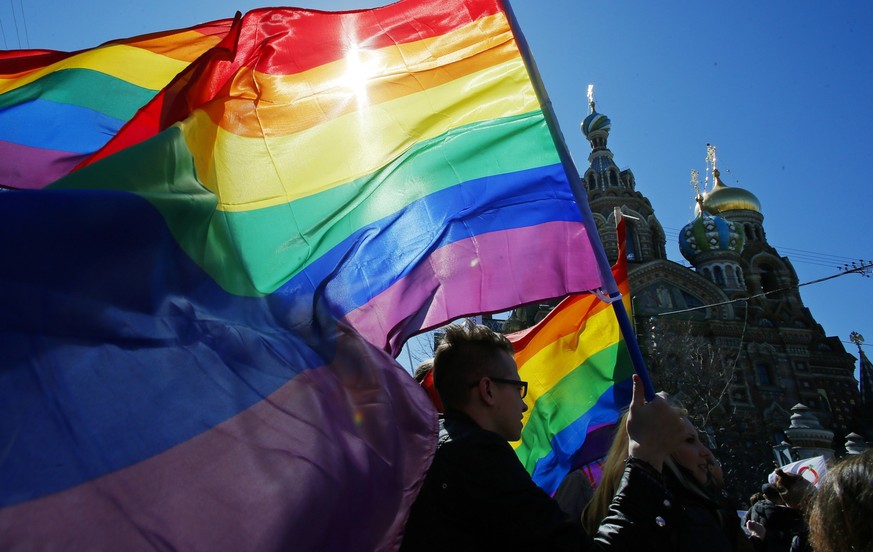 FILE - Gay rights activists carry rainbow flags as they march during a May Day rally in St. Petersburg, Russia, Wednesday, May 1, 2013. Russia’s Supreme Court on Thursday, Nov. 30, 2023, effectively o ...
