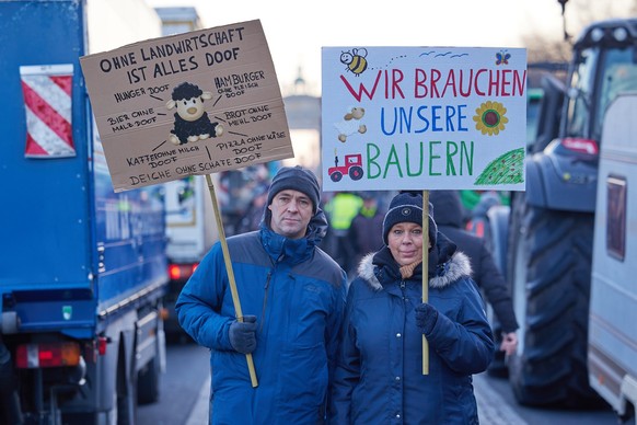08.01.2024, Berlin: Transparente mit der Aufschrift &quot;Ohne Landwirtschaft ist alles doof&quot; und &quot;Wir brauchen unsere Bauern&quot; sind bei einem Bauernprotest auf der Stra�e des 17. Juni v ...