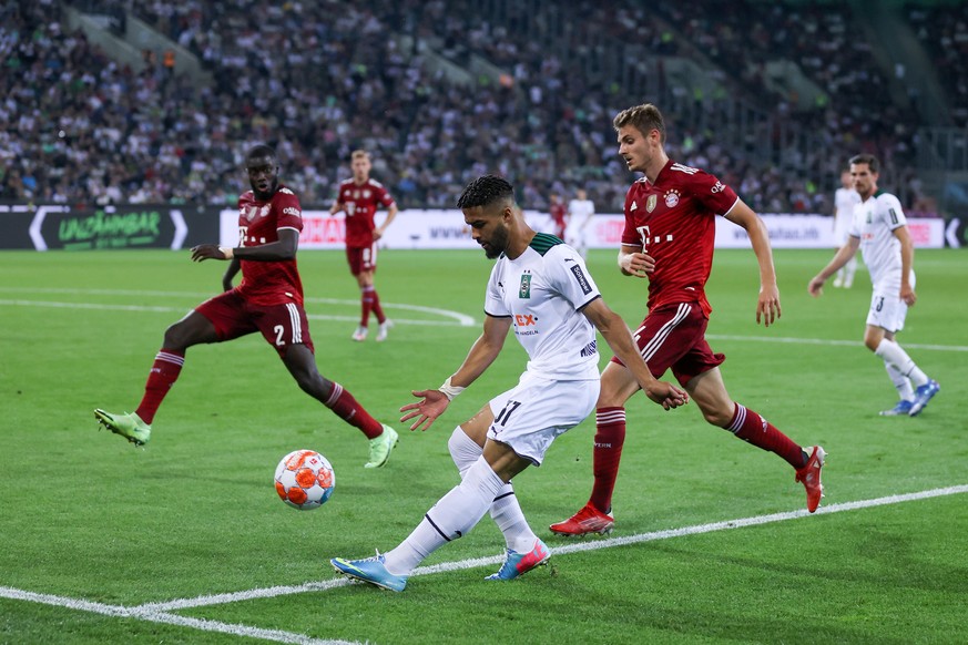 MOENCHENGLADBACH, GERMANY - AUGUST 13: Keanan Bennetts of Borussia Monchengladbach crosses the ball whilst under pressure from Josip Stanisic of Bayern Munich during the Bundesliga match between Borus ...