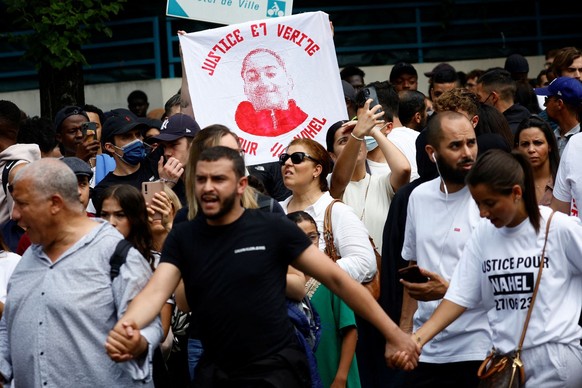 People attend a march in tribute to Nahel, a 17-year-old teenager killed by a French police officer during a traffic stop, in Nanterre, Paris suburb, France, June 29, 2023. The slogan reads &quot;Just ...
