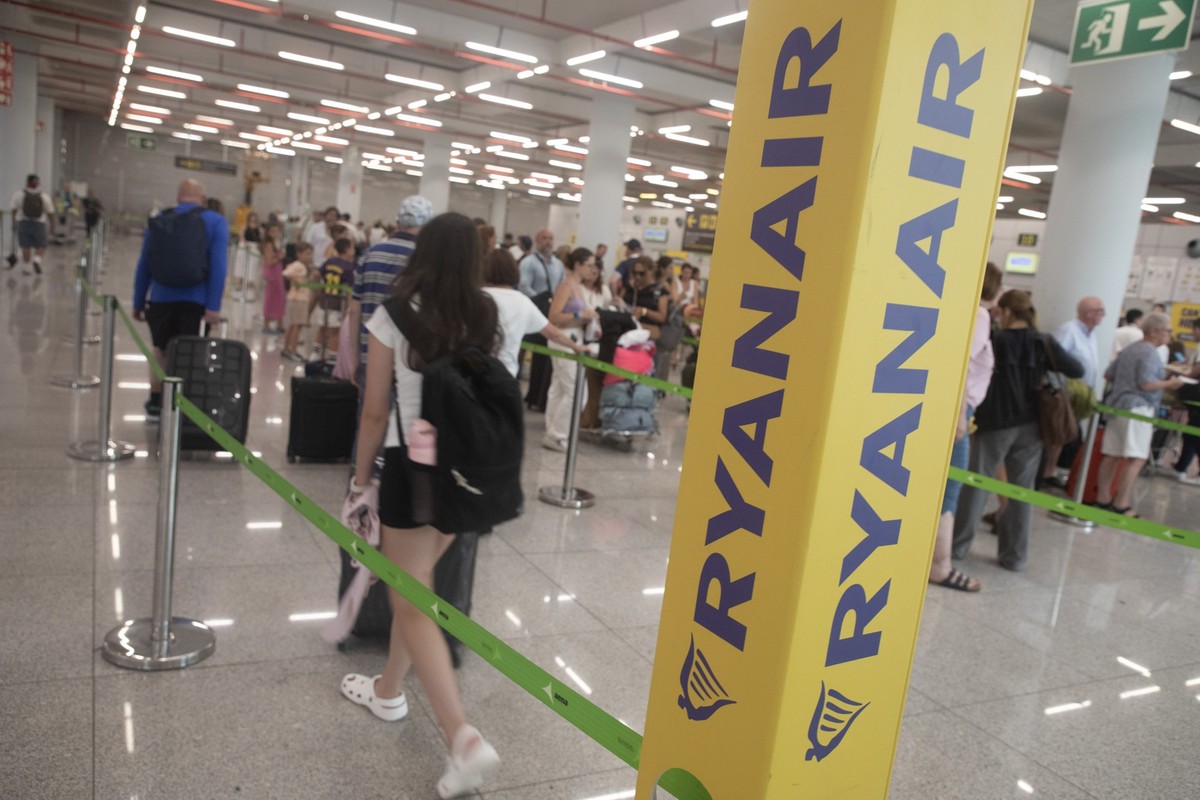 05.07.2025, Spanien, Palma: Passagiere stehen in der Schlange vor dem Ryanair-Check-In-Schalter am Flughafen. Wegen eines falschen Feueralarms mussten Dutzende Menschen einen Ryanair-Flieger am Flugha ...