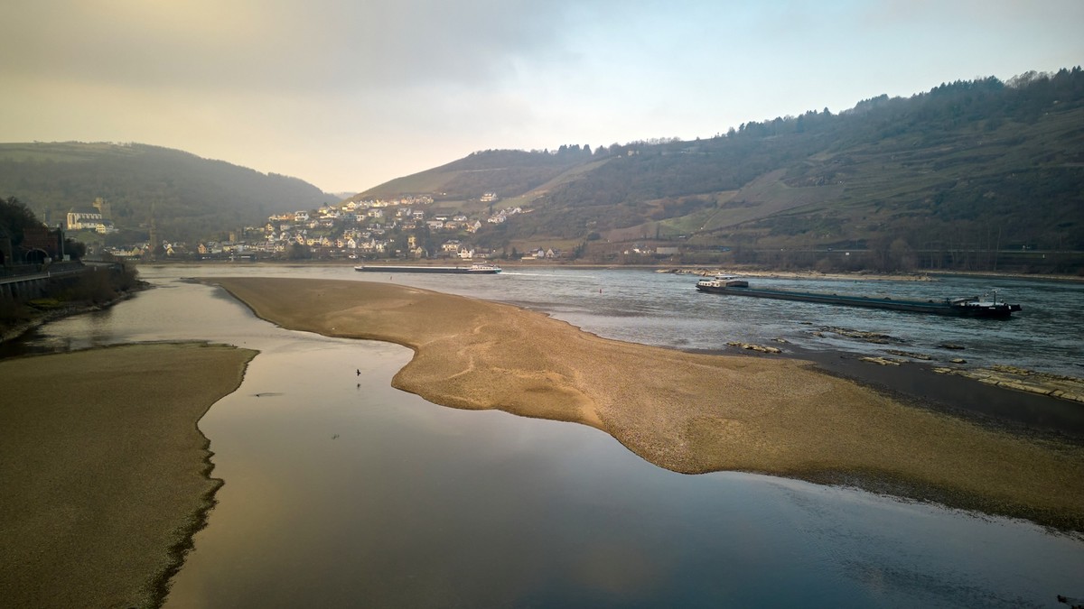 03.03.2023, Rheinland-Pfalz, Oberwesel: Schiffe passieren bei niedrigem Wasserstand die Sandbank am Jungfrauengrund am Mittelrhein (Luftaufnahme mit Drohne). Derzeit führt der Rhein für die Jahreszeit ...