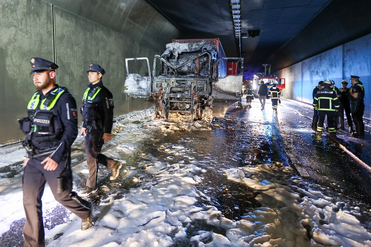04.07.2024, Hamburg: Einsatzkr�fte stehen im Elbtunnel an einer ausgebrannten Lkw-Zugmaschine. Wegen des Brandes in der R�hre des Elbtunnels in Fahrtrichtung Norden war der Hamburger Elbtunnel zeitwei ...