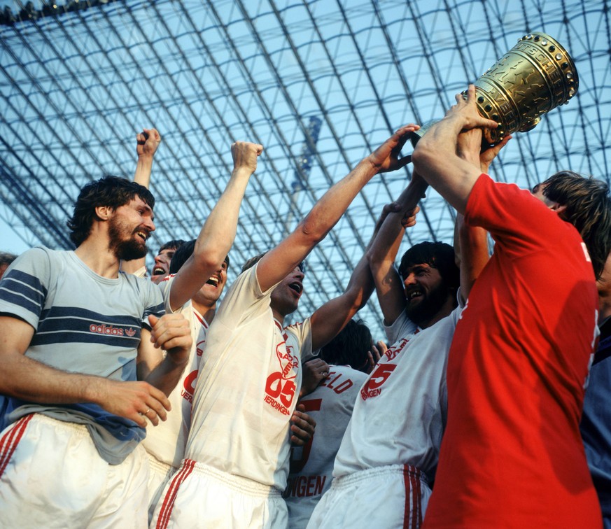 Alle wollen mal anfassen: Die Uerdinger Spieler können's kaum glauben. Der zweite von rechts ist übrigens Friedhelm Funkel. Das Finale fand 1985 zum ersten Mal im Berliner Olympiastadion statt, wo es  ...