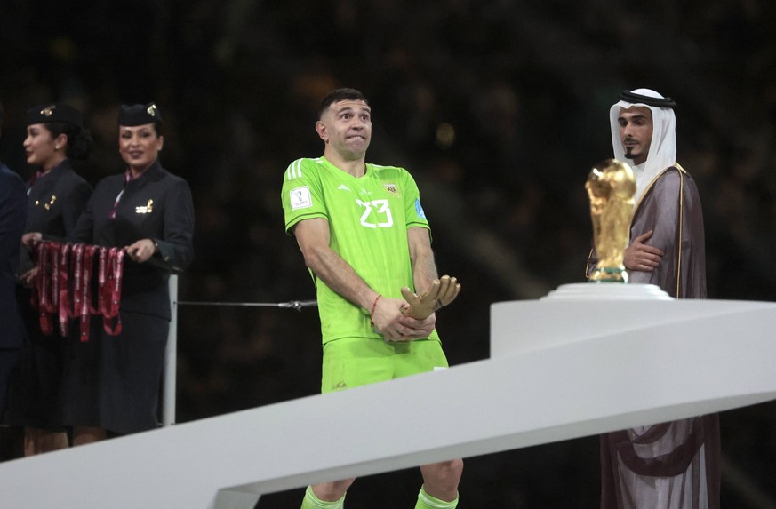 Emiliano Martnez receives the trophy for the best goalkeeper the final of the FIFA World Cup, WM, Weltmeisterschaft, Fussball soccer tournament between Argentina and France at Lusail stadium in Lusail ...