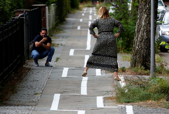 A women poses for a happy snap on a bike lane, after the lane marking was restored recently in a strange zigzag shape at Zehlendorf district in Berlin, Germany, August 11, 2018. REUTERS/Fabrizio Bensc ...