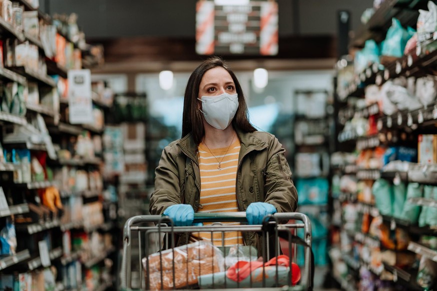 Woman pushing supermarket cart during COVID-19