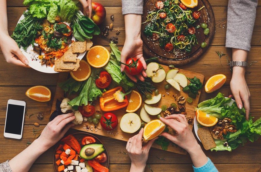 Eating healthy food, fruits and vegetables dinner table. Women at home together, top view, flat lay, crop