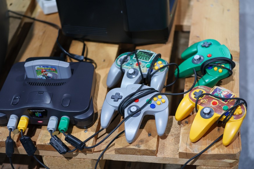 13.04.2023, Sachsen, Leipzig: Eine Nintendo 64 Spielkonsole liegt in einem Retro-Bereich des Gamingfestival «CAGGTUS» auf der Leipziger Messe. Das «CAGGTUS»-Festival findet vom 14. bis 16. April statt ...