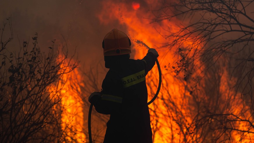 03.08.2021, Griechenland, Athen: Ein Feuerwehrmann k