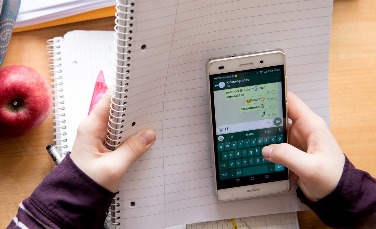 ARCHIV - 06.02.2018, Bayern, M�nchen: Eine Sch�lerin sitzt mit ihrem Handy und ihren Schulsachen an einem Schreibtisch. (zu dpa: �Griechenland: Handys bleiben in den Schultaschen - sonst Verweis�) Fot ...