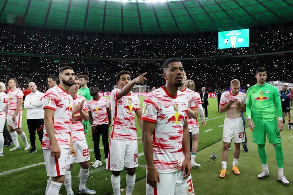 BERLIN, GERMANY - MAY 21: Benjamin Henrichs of RB Leipzig and teammates wait to lift the trophy after a medical incident, whilst fans light up the stadium with their phone torches following the final  ...