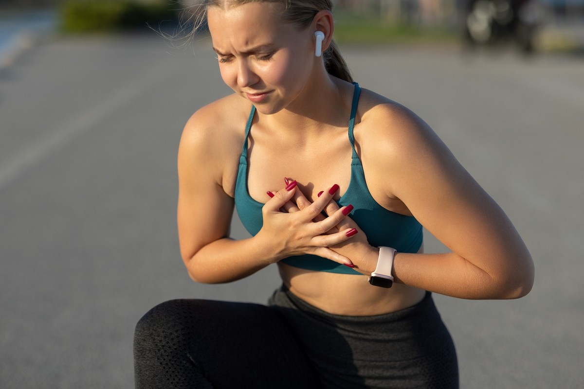 Young woman with chest pain after jogging work out