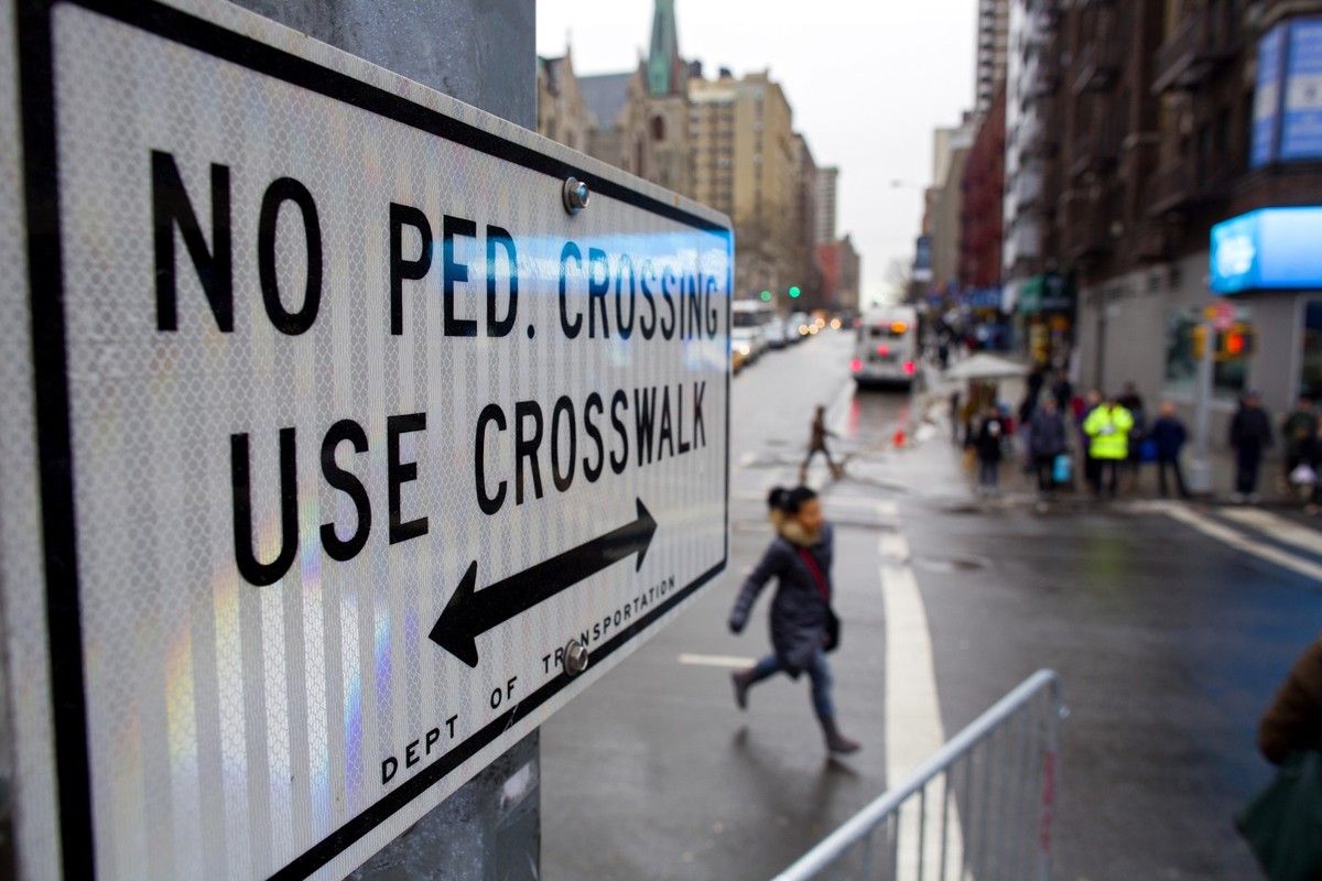 FILE - After crossing outside a crosswalk, a pedestrian, center, runs towards a crosswalk at the busy intersection of W. 96th Street and Broadway in the Upper West Side of New York Monday, Jan. 27, 20 ...