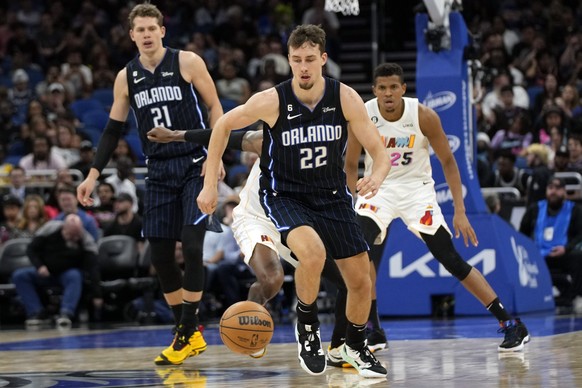 ARCHIV - 11.02.2023, USA, Orlando: Basketball: NBA, Hauptrunde, Orlando Magic - Miami Heat. Franz Wagner (22) von den Orlando Magic rennt einem verlorenen Ball hinterher, vor dem Center Moritz Wagner  ...