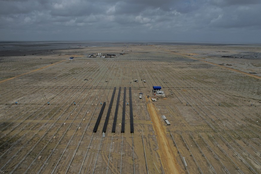 Solar panels are installed at an under-construction site of Adani Green Energy Limited&#039;s Renewable Energy Park in the salt desert of Karim Shahi village, near Khavda, Bhuj district near the India ...