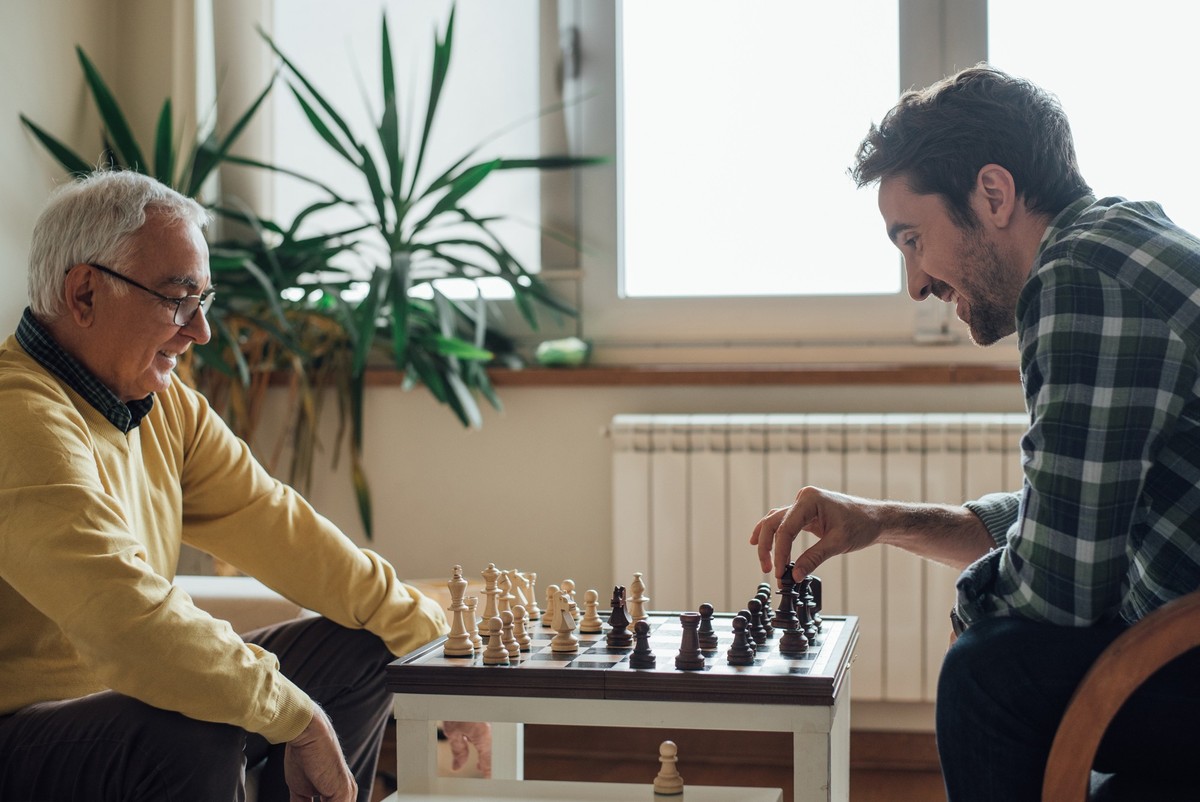 Father and adult son playing chess