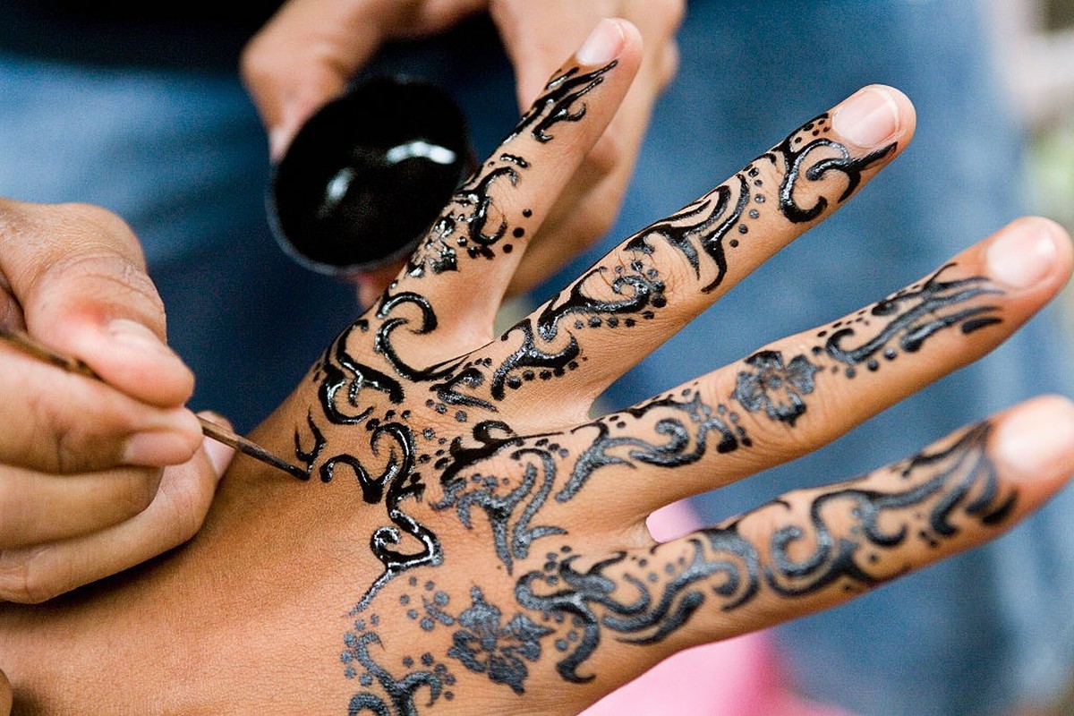 Henna tattoo being painted onto the hand of a female Western tourist in Bali, Indonesia (Photo by Barry Lewis/In Pictures Ltd./Corbis via Getty Images)