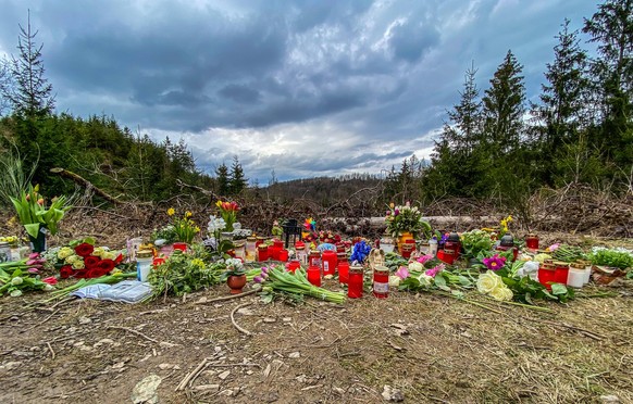 In der Naehe Nähe Fundortes der ermordeten Luise F. aus Freudenberg wurden Blumen, Kerzen und weitere Gegenstaende Gegenstände abgelegt. Am Himmel sind dunkle Wolken. Trauer am 18.03.2023 in Freudenbe ...