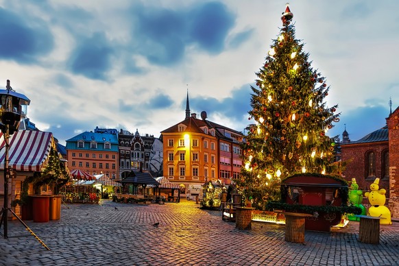 Christmas market and the main Christmas tree located at the Dome square in old Riga, Latvia. At the market people can buy festive souvenirs, presents. Selective focus
