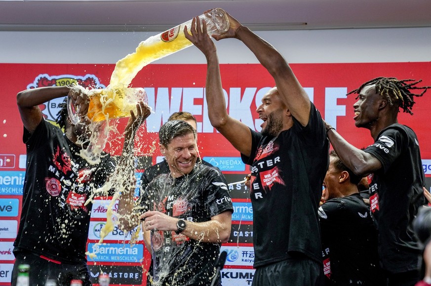 Leverkusen&#039;s head coach Xabi Alonso , centre, is sprayed with beer after Bayer Leverkusen won the German Bundesliga title beating Werder Bremen in Leverkusen, Germany, Sunday, April 14, 2024. (AP ...