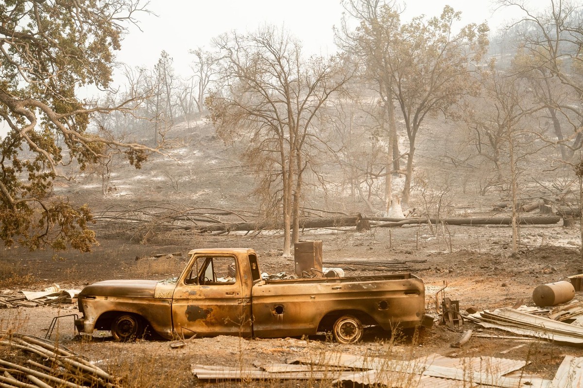 27.07.2024, USA, Tehama County: Ein ausgebranntes Fahrzeug liegt nach dem Park Fire, das durch die Gemeinde Tehama County, wütete, unterhalb eines Hügels in Paynes Creek. Foto: Noah Berger/FR34727 AP/ ...