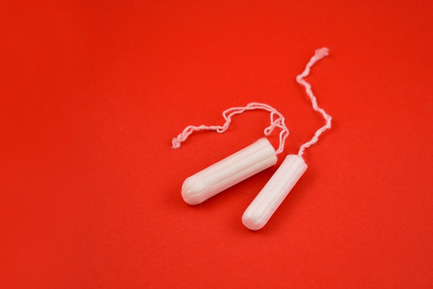 Feminine hygiene product. White tampons on a red background. Tampons for women