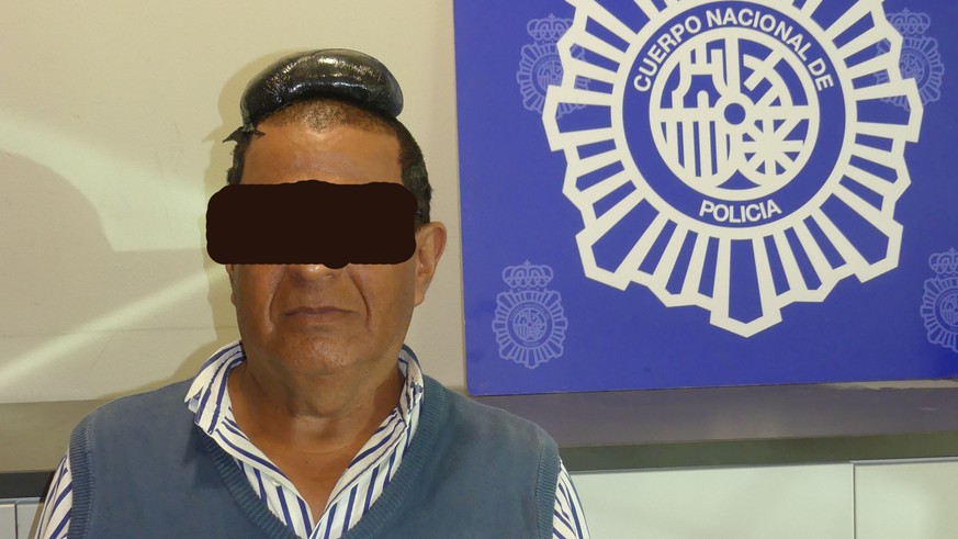 A man poses with a drug package on his head, that he hid under a toupee, after being arrested in Barcelona, Spain, in this picture released on July 16, 2019. Spanish National Police via REUTERS ATTENT ...