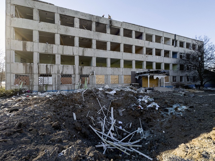 Municipal workers clear the rubble on the roof of College No. 47 which was damaged by a Russian rocket attack in Kramatorsk, Ukraine, Monday, Jan. 9, 2023. (AP Photo/Evgeniy Maloletka)