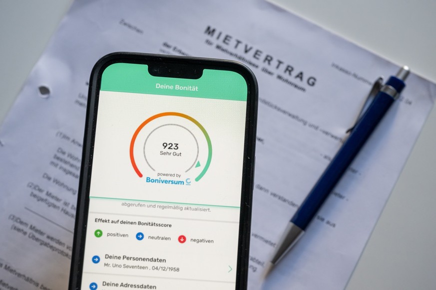 ILLUSTRATION - 18.07.2023, Hessen, Wiesbaden: ILLUSTRATION - Ein Screenshot der App &quot;Bonify&quot; ist auf dem Bildschirm eines Mobiltelefon vor einem Mietvertrag zu sehen. Auf einer Online-Presse ...