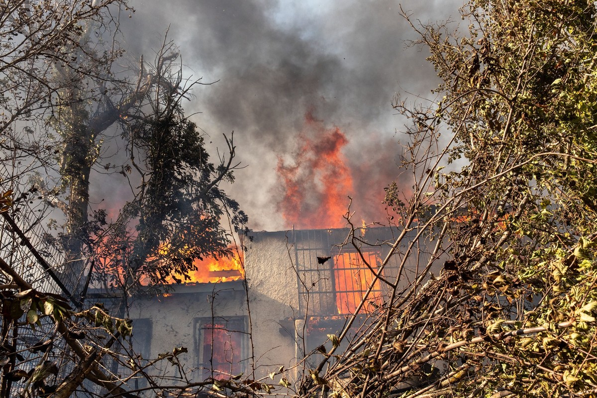 11.08.2024, Griechenland, Varnavas: Ein Haus f�ngt w�hrend eines gro�en Waldbrandes in Varnavas, etwa 35 km von Athen Feuer. Griechische Feuerwehrleute k�mpften am Sonntag in der N�he von Athen mehrer ...