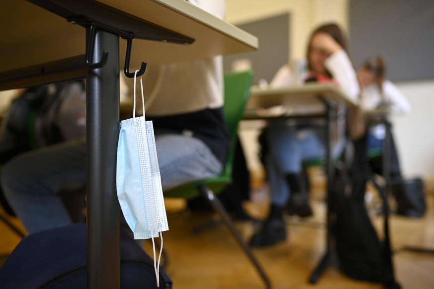 Mundschutzmaske hängt an Schülertisch, Präsenzunterricht, Corona-Krise, Stuttgart, Baden-Württemberg, Deutschland, Europa *** Mouth mask hangs at students desk, attendance lessons, Corona crisis, Stut ...