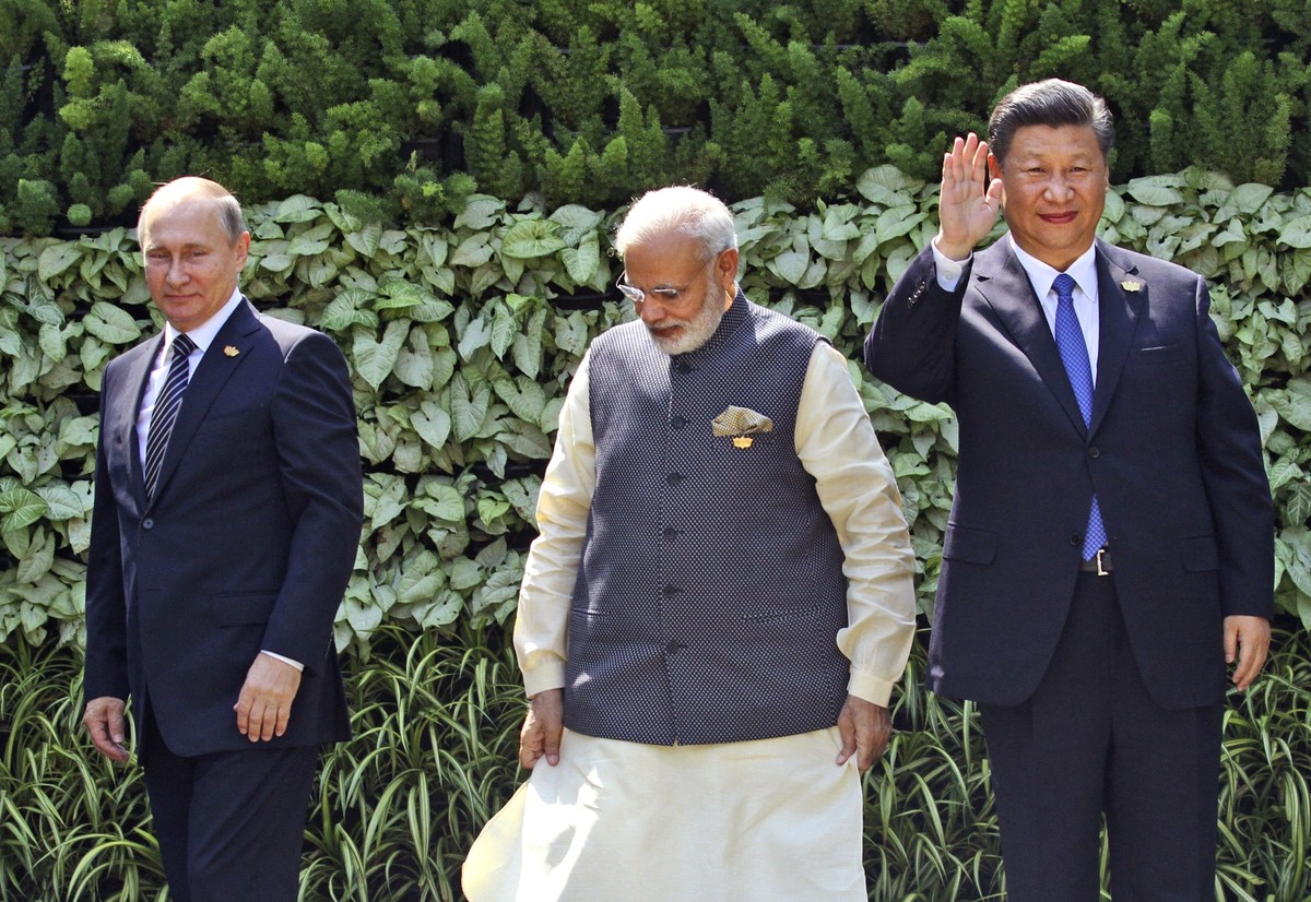 FILE- Russian President Vladimir Putin, Indian Prime Minister Narendra Modi, and Chinese President Xi Jinping gather for a group photo at the start of the BRICS Summit in Goa, India, Sunday, Oct. 16,  ...