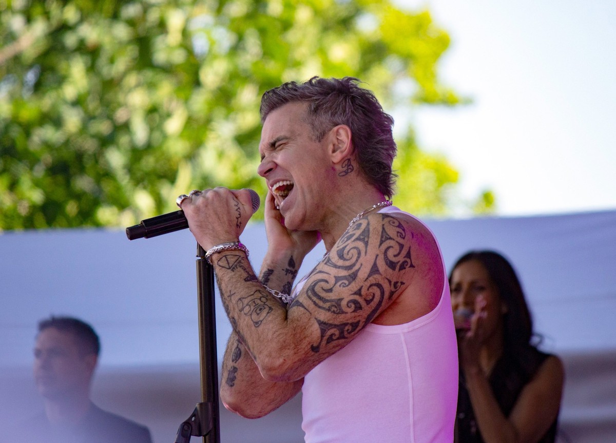 ARCHIV - 02.01.2025, Australien, Melbourne: Robbie Williams singt bei einem kostenlosen Konzert im Freien auf dem Federation Square. (zu dpa: