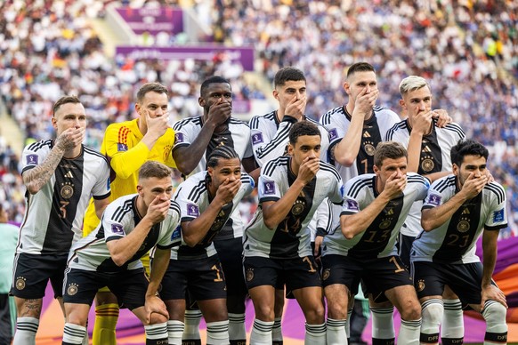 221123 The starting eleven of Germany hold their hands over their mouths in a protest as they pose for a photo ahead of the FIFA World Cup, WM, Weltmeisterschaft, Fussball 2022 football match between  ...