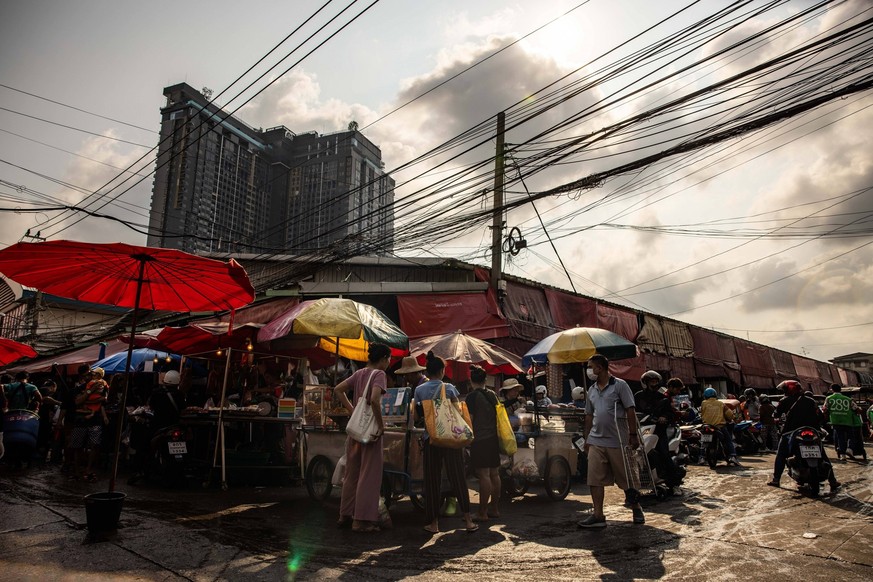 April 28, 2024, Bangkok, Thailand: People move around a market under the scorching sun during a period or severe heat warnings from the Thai meteorological department in Bangkok, Thailand, on Sunday,  ...