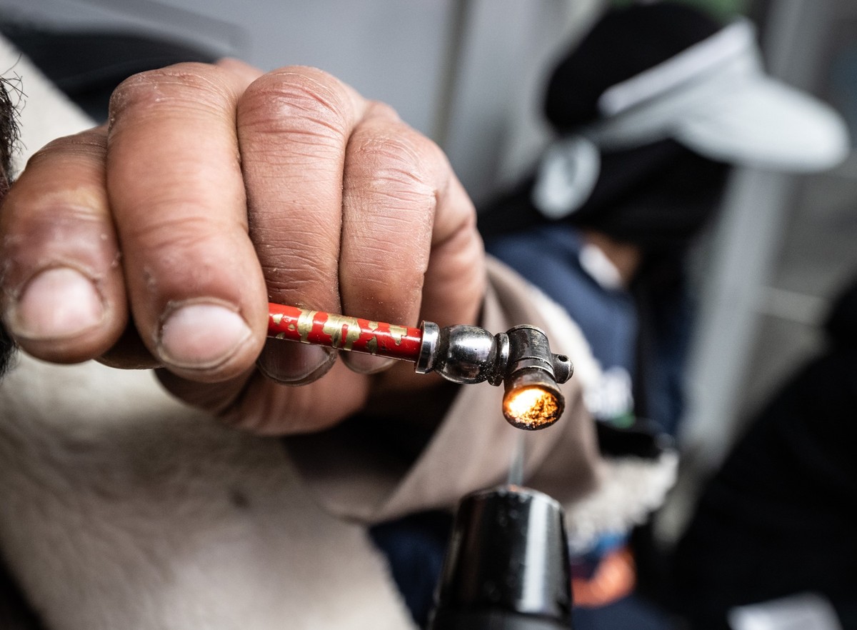 PRODUKTION - 06.05.2024, Hessen, Frankfurt/Main: Ein Süchtiger zündet sich in einem Hauseingang im Bahnhofsviertel eine Crack-Pfeife an. Crack gilt als die am meisten verbreitete Droge in Frankfurt (Z ...