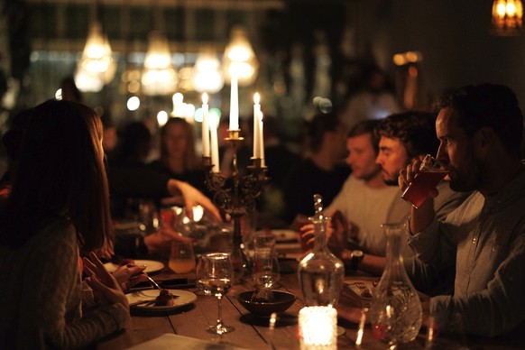 FILE - A group of diners have a drink and candle lit dinner at Brasserie Surrealiste in Brussels, Wednesday, Sept. 28, 2022, during a simulation of dinner without using energy. Leading up to Thursday, ...