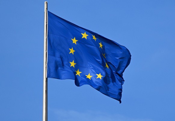 ARCHIV - 07.11.2022, Berlin: Die Flagge der EU auf dem Reichstag weht im Wind. Zum besseren Schutz von Arbeitnehmerinnen und Arbeitnehmern hat das EU-Parlament neue Grenzwerte f�r gesundheitssch�dlich ...