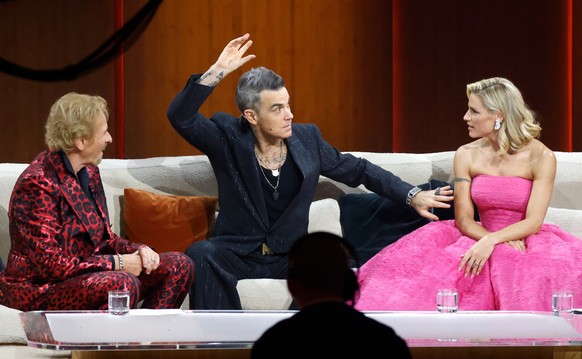 19.11.2022, Baden-W�rttemberg, Friedrichshafen: Der britische Popstar Robbie Williams (2.v.l.) sitzt bei der ZDF-Show &quot;Wetten, dass..?&quot; mit Thomas Gottschalk (l), Michelle Hunziker, Comedian ...