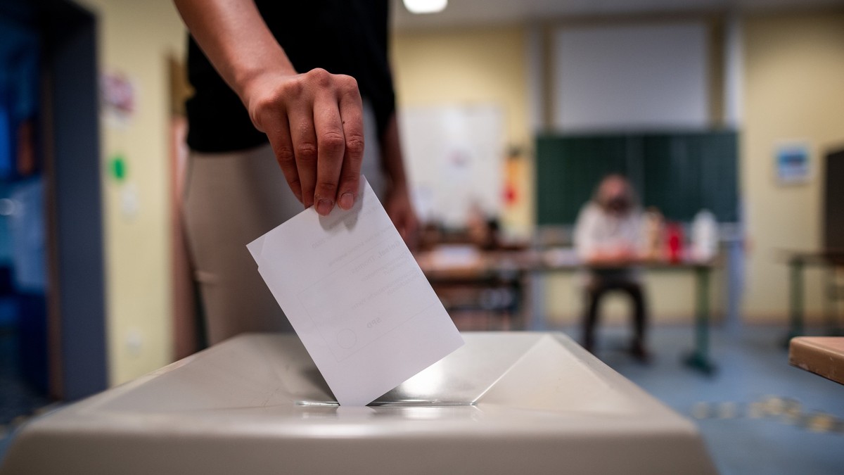 ARCHIV - 27.09.2020, Nordrhein-Westfalen, Düsseldorf: Eine Frau wirft einen Wahlzettel in eine Wahlurne in Düsseldorf. Rund 13,7 Millionen Bürger dürfen am Sonntag an den Kommunalwahlen in Nordrhein-W ...