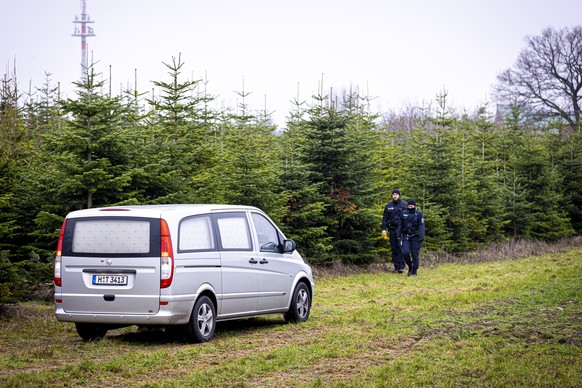 Ein Leichenwagen hält auf einer Wiese in Wunstorf, die die Polizei auf der Suche nach dem vermissten Jungen durchkämmt hat.