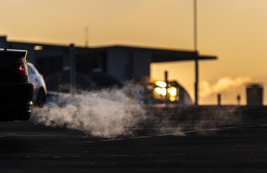 Abgase von einem Auto zeichnen sich ab vor der untergehenden Sonne in Berlin, 11.01.2022. Copyright: Florian Gaertner/photothek.de