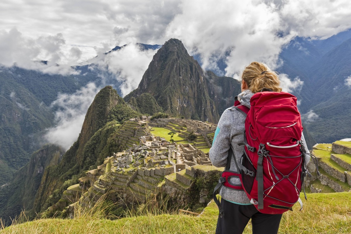 Peru, Andes, Urubamba Valley, tourist with red backpack at Machu Picchu with mountain Huayna Picchu model released Symbolfoto PUBLICATIONxINxGERxSUIxAUTxHUNxONLY FOF08776