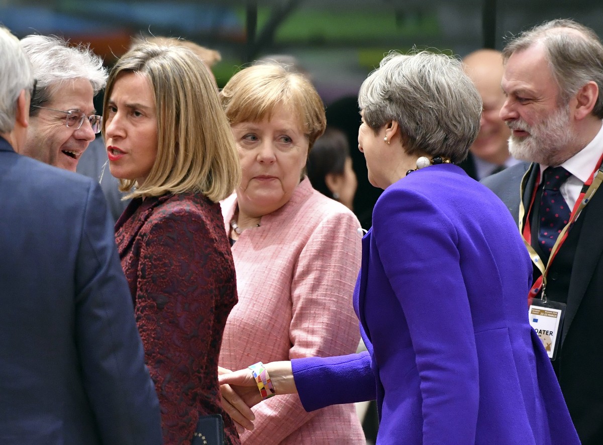 British Prime Minister Theresa May, third right, reaches out to shake hands with Italian Prime Minister Paolo Gentiloni, second left, during a round table meeting at an EU summit at the Europa buildin ...