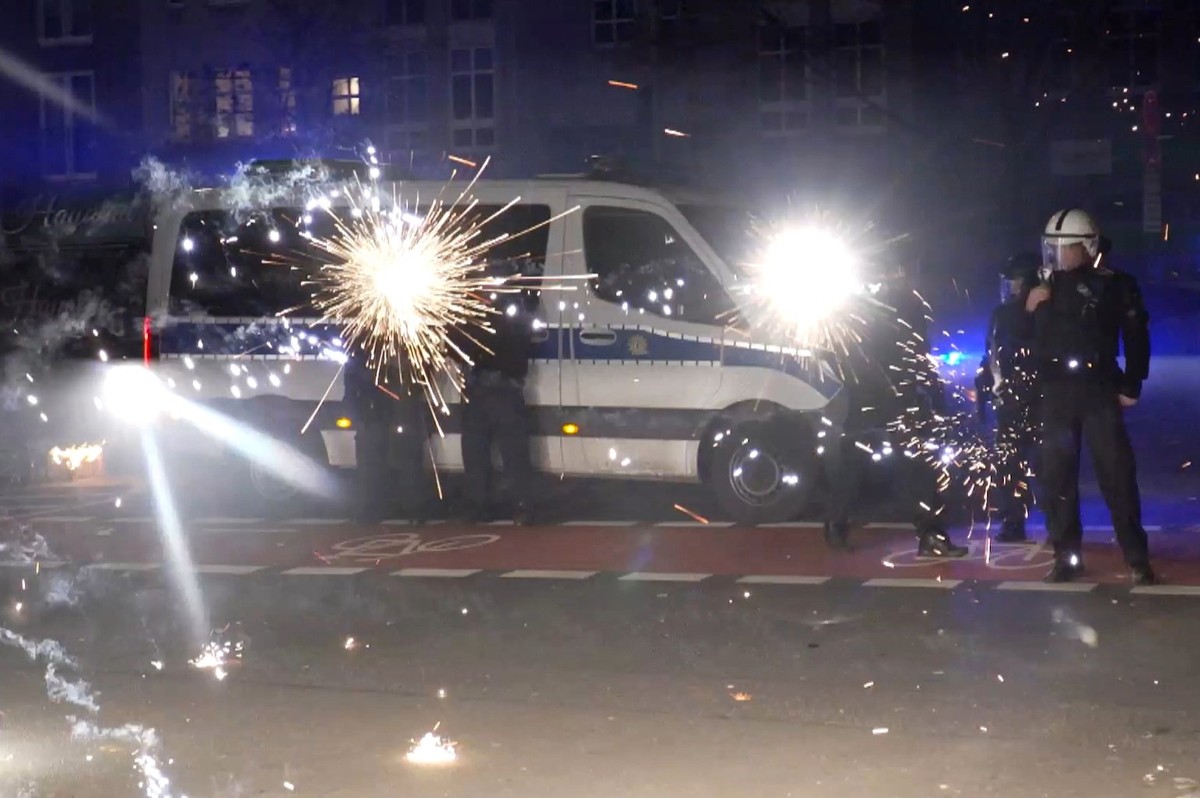 ARCHIV - 31.12.2022, Berlin: Polizeibeamte stehen in der Silvesternacht hinter explodierendem Feuerwerk. (Videograb) (zu dpa: