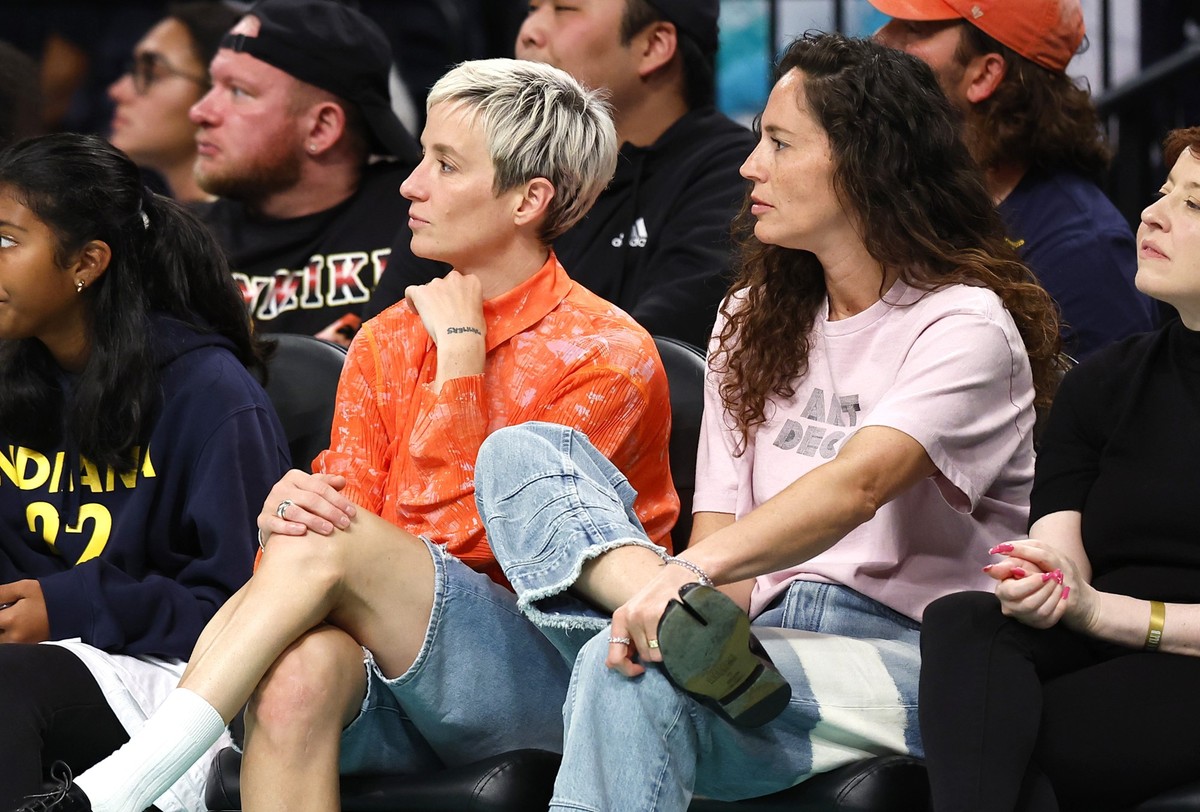 Megan Rapinoe, left, and Sue Bird, right, sit courtside during the second half of the WNBA basketball game between the Indiana Fever and the New York Liberty, Saturday, May 18, 2024, in New York. The  ...
