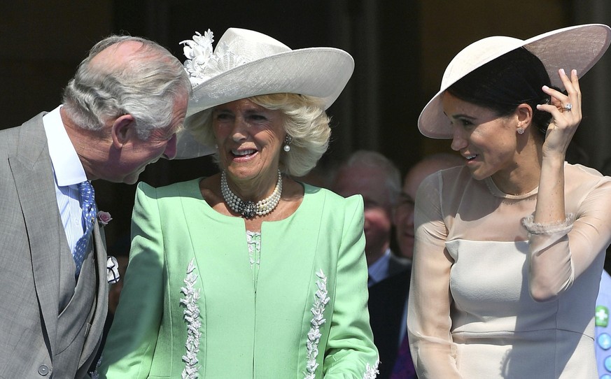FILE - In this Tuesday, May 22, 2018 file photo, Britian&#039;s Prince Charles, left, speaks with Camilla, the Duchess of Cornwall and Meghan, the Duchess of Sussex, during a garden party at Buckingha ...