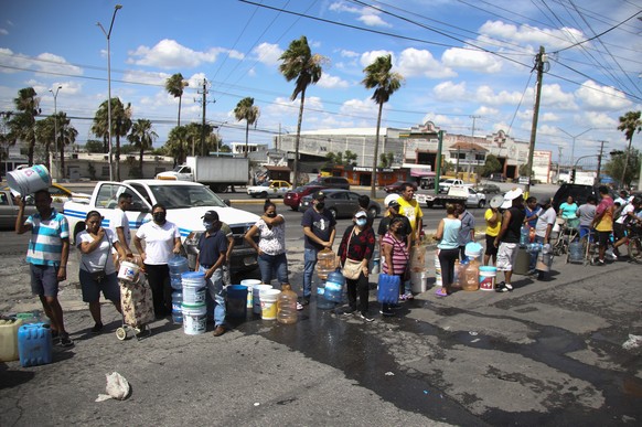 20. Juni 2022, Mexiko, Monterrey: Anwohner stehen Schlange, um an einer öffentlichen Sammelstelle Wasser in Plastikbehältern zu sammeln.  Die örtlichen Behörden haben mit der Arbeit begonnen...