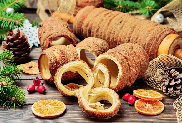 Trdelnik is a baked delicacy on a spit and charcoal dough with sugar, cinnamon and vanilla. Christmas sweets, street food. Czech and Moravian cuisine.